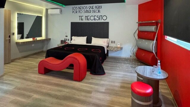Habitación discreta de motel, con tonos rojos.