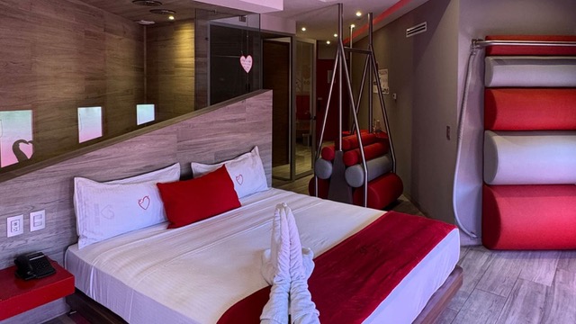 Habitación de motel con un cisne de toalla en la cama