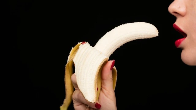 Mujer jugando un juego erótico con un plátano
