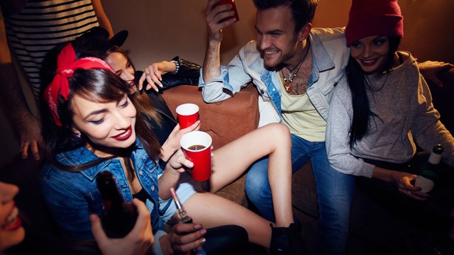 Un grupo de jóvenes tomando en una habitación de motel, en una fiesta privada