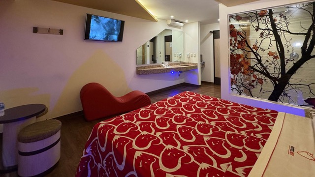 Habitación de motel simple, con cama roja
